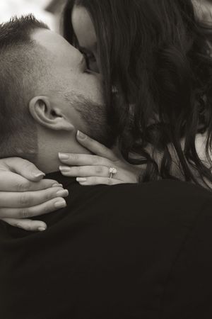 An intimate black and white photo of a couple embracing.