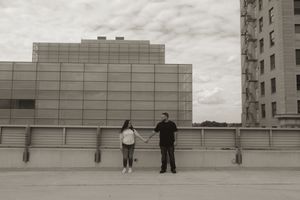 Distant view of two people standing on an empty rooftop parking area.