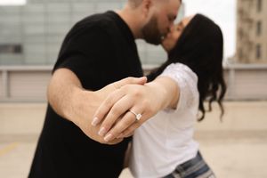 Couple sharing an intimate moment on a rooftop parking area.