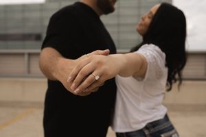Two people embracing on an urban rooftop with industrial buildings in background.
