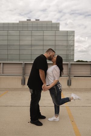 Series of romantic poses captured on concrete rooftop parking area.