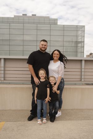 Family group posing together on urban rooftop setting.