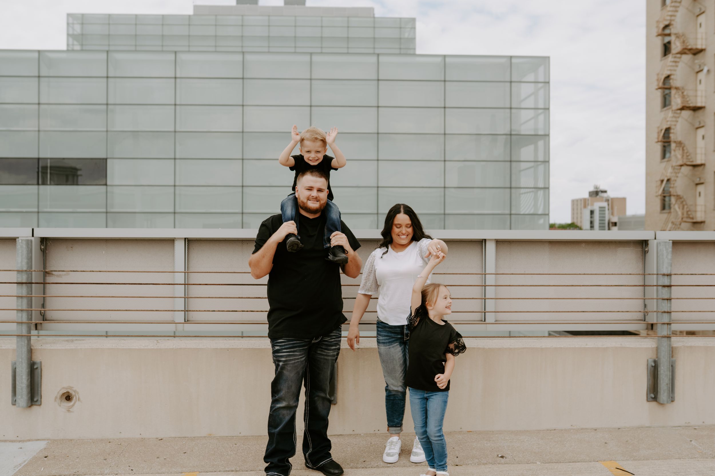 Couple running and playing together on a modern rooftop with white architectural elements.