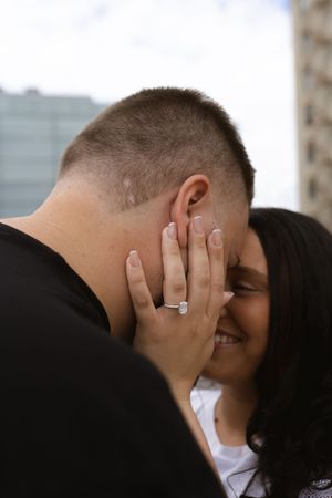 A couple embracing in a tender moment with hands gently placed on each other's faces.