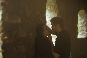 A romantic moment captured in the shadows of ancient stone architecture.