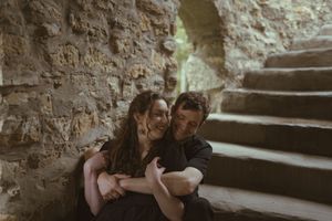 A tender moment shared between two people on stone steps in dim lighting.