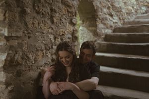 An intimate embrace captured on ancient stone steps in moody lighting.