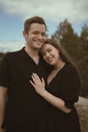 A joyful couple shares laughter while embracing outdoors.
