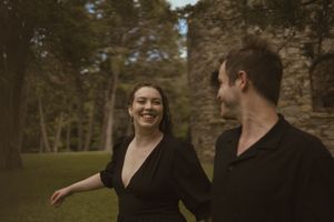 A playful moment captured between two people near a historic stone structure.