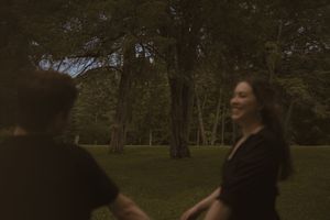 A candid moment of joy captured between two people in a park setting.