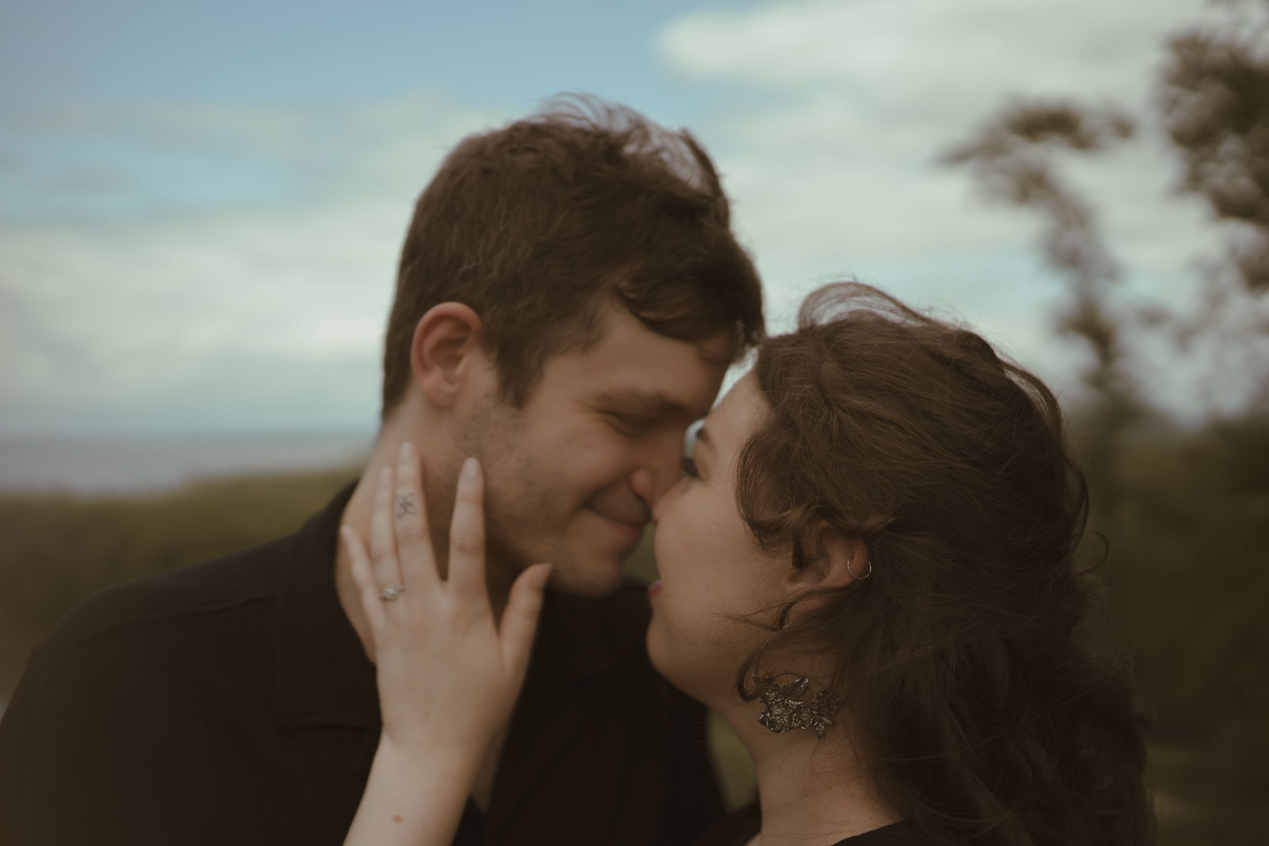 A romantic close-up of a couple sharing an intimate moment outdoors.