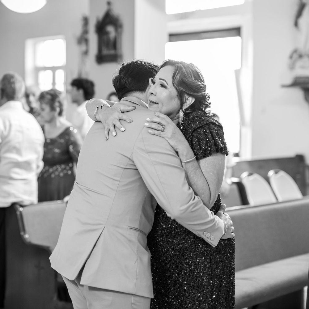 Black and white photograph showing various joyful embraces and moments during what appears to be a formal event or celebration.