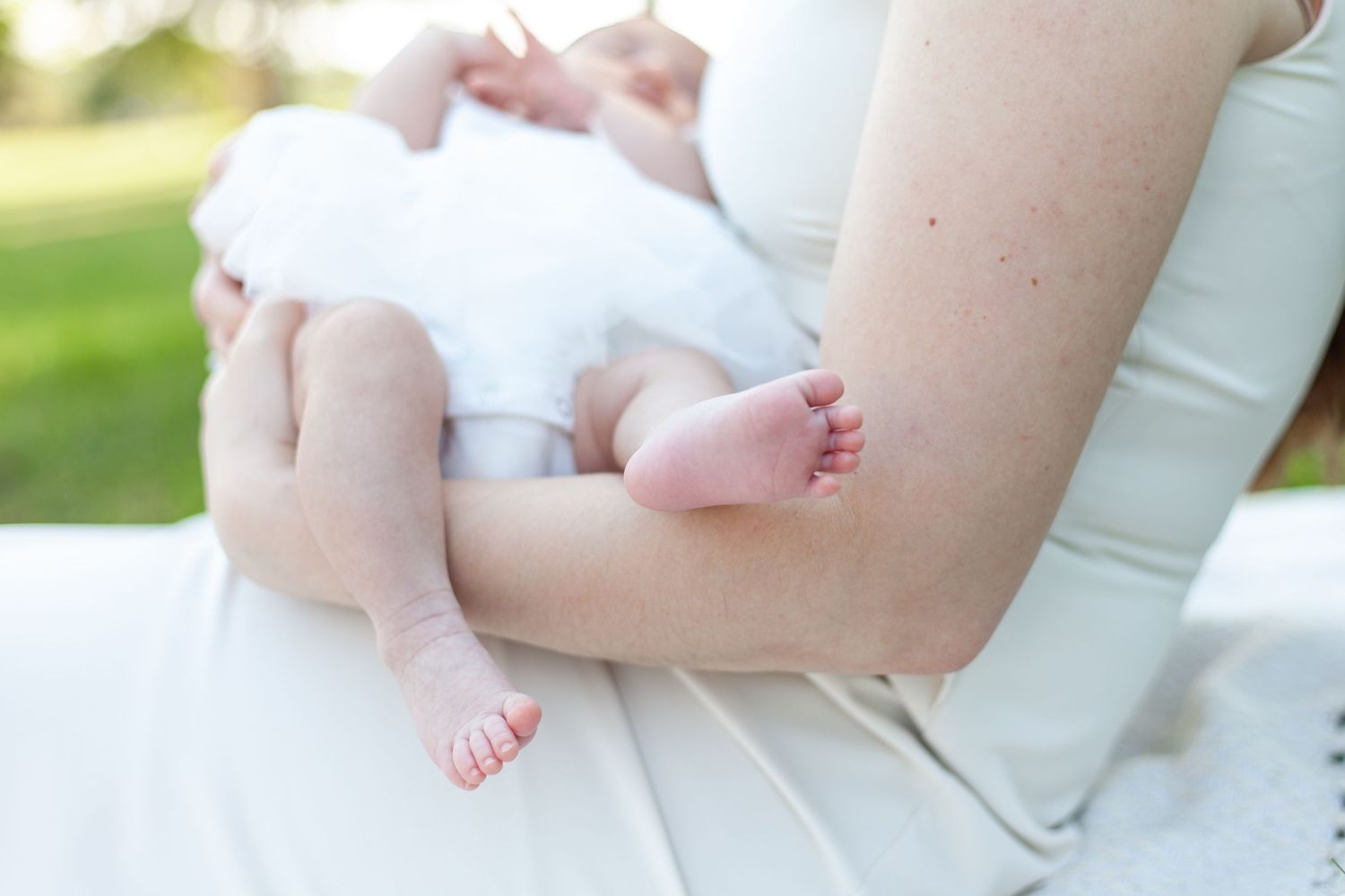 A detail shot of baby toes in a mother's arm in this outdoor Raleigh, NC newborn photo session.