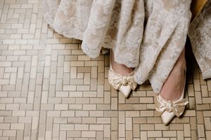Wedding guests' feet dance and celebrate on a brick paved floor at an elegant reception celebration.