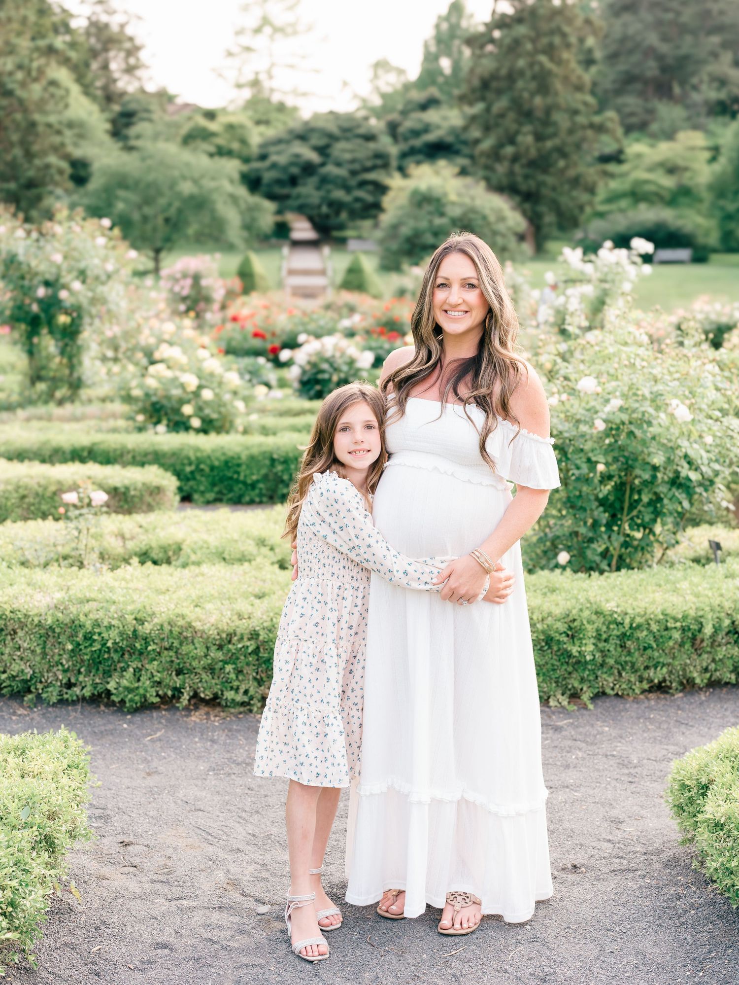 An expecting mother wraps her arounds around her daughter during a maternity photo session in holmdel New Jersey.