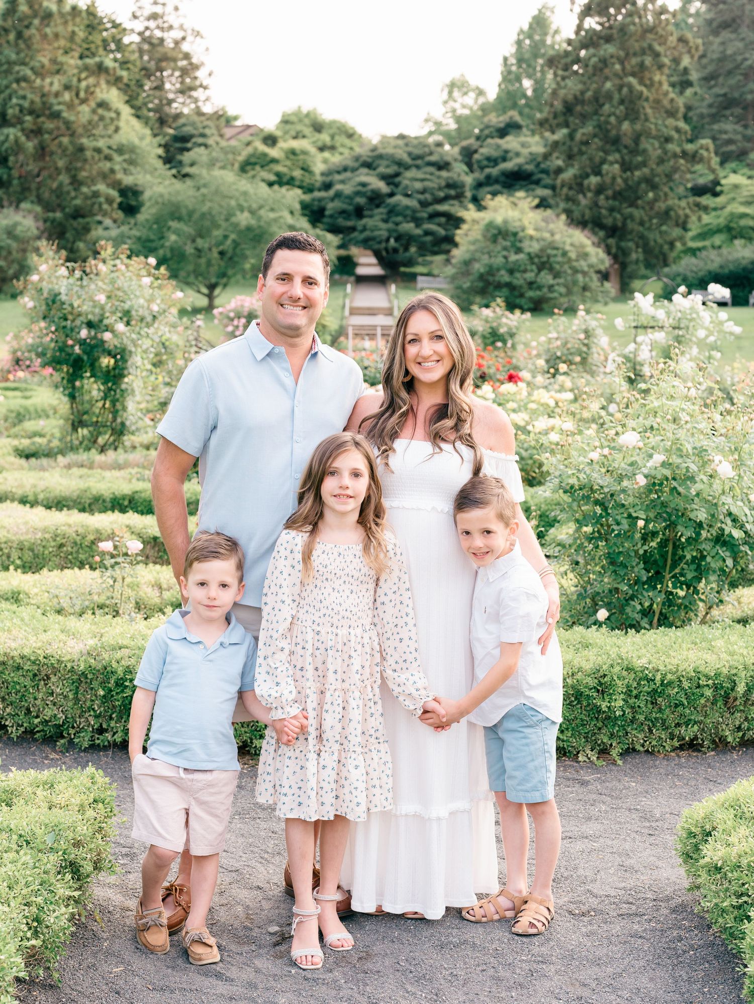 A family of five with expecting mother poses for a photo session at deep cut gardens in Middle town NJ.
