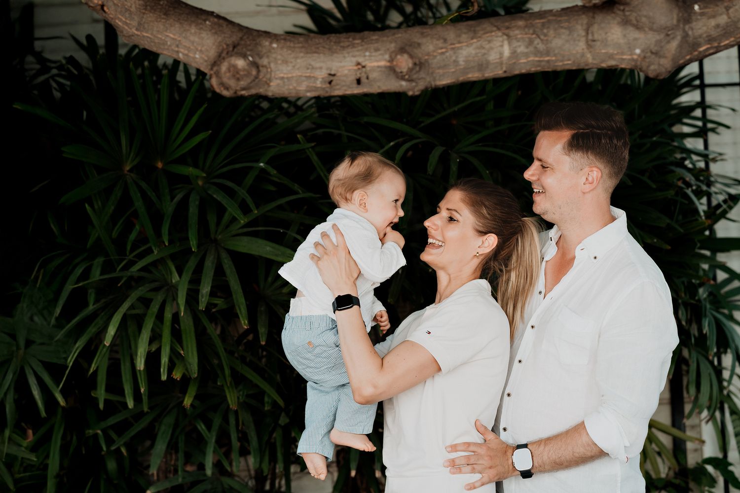 Fotografía de familia internacional en Mazatlán, padres e hijo recién nacido disfrutando juntos.