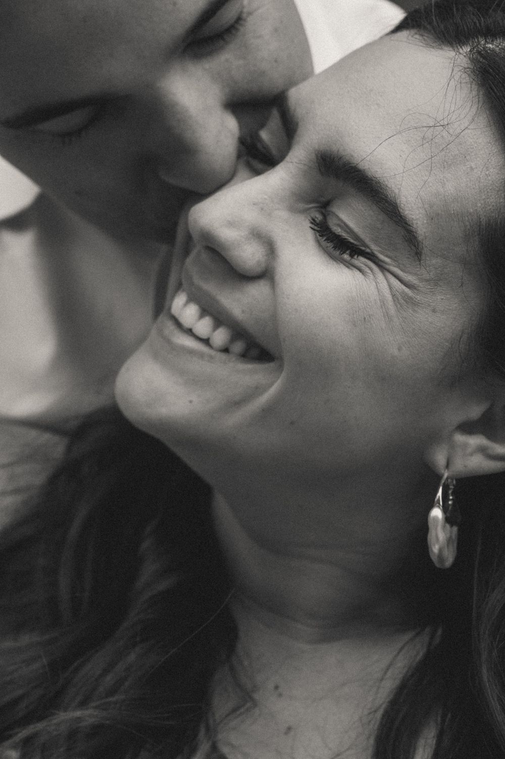 Black and white close-up photo series capturing intimate expressions and laughter between partners.