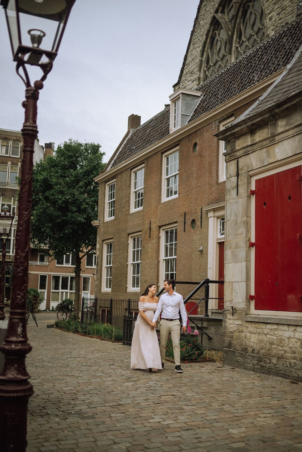 Cobblestone street scene with red doors and historic architecture in Amsterdam.