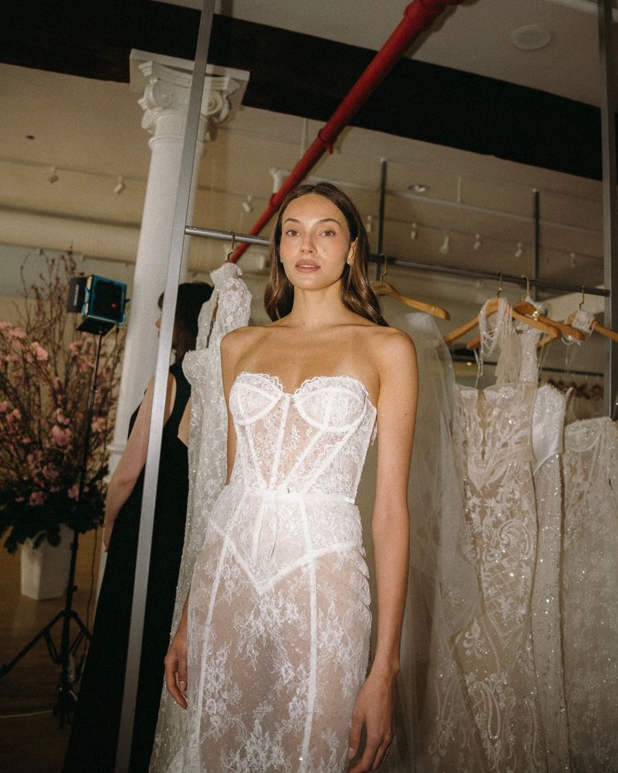 Wedding dresses with delicate lace and corset details displayed in a bridal boutique.
