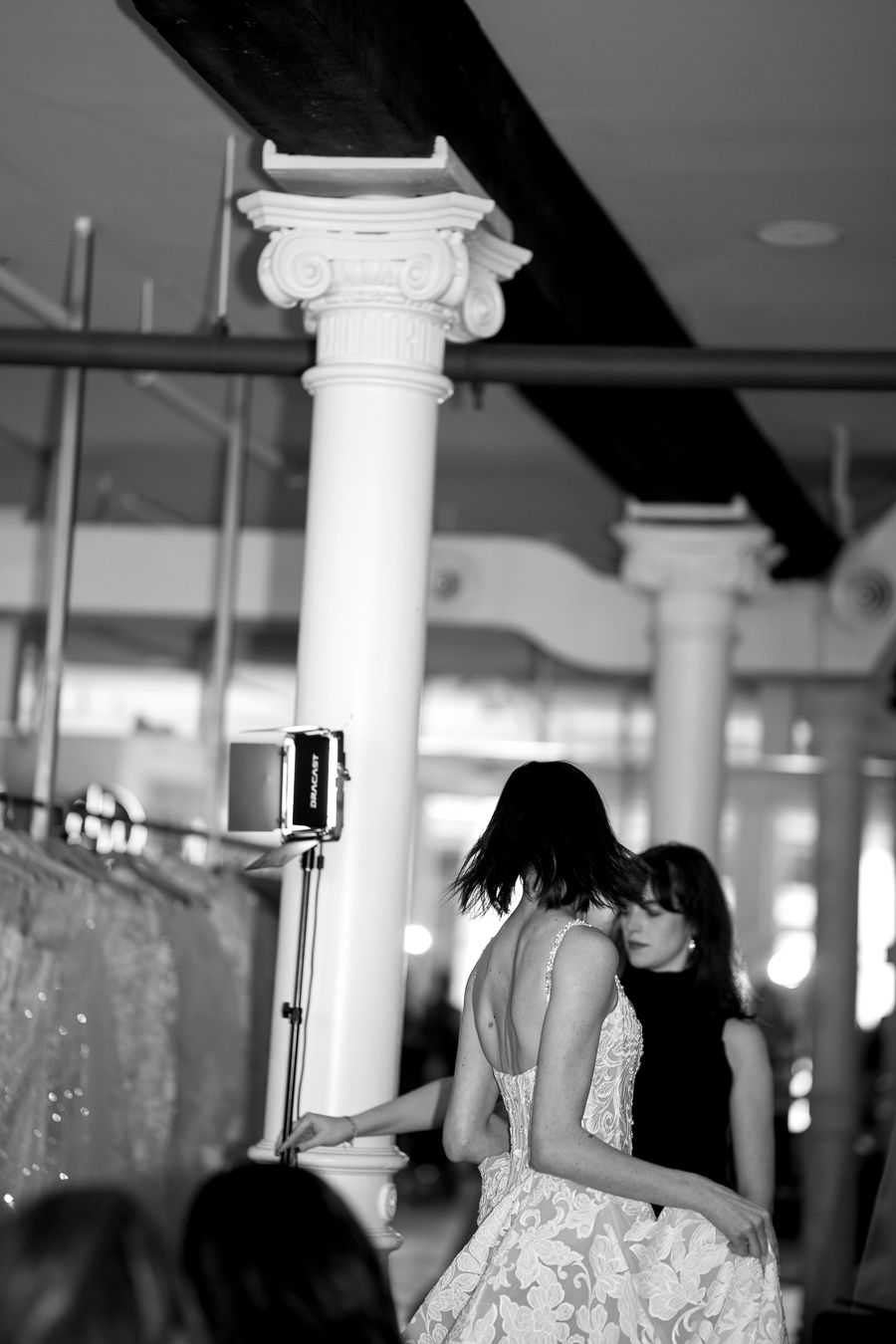 Black and white photo of a dance floor with white columns and sparkling decorations.