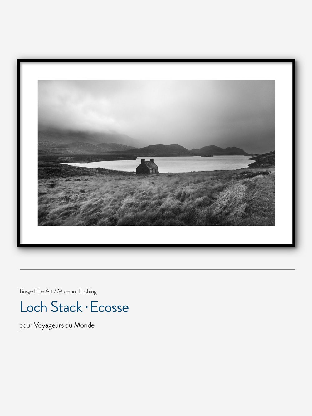Black and white panoramic landscape photograph of Loch Stack in Scotland showing mountains and water in moody lighting.