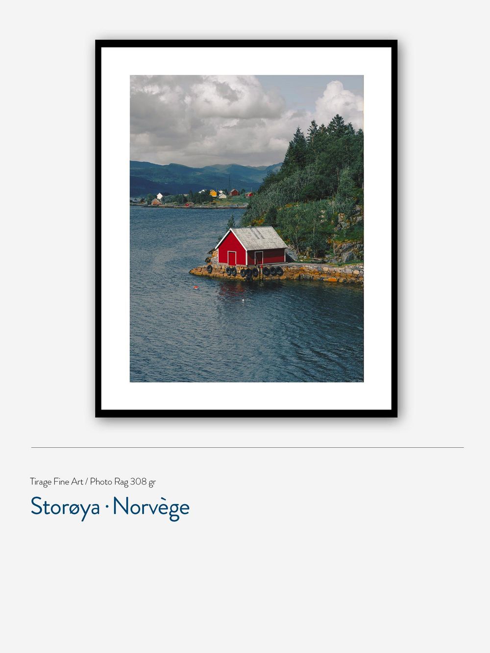 Framed fine art print of a red boathouse on a rocky Norwegian island, surrounded by calm fjord waters and lush green hills.