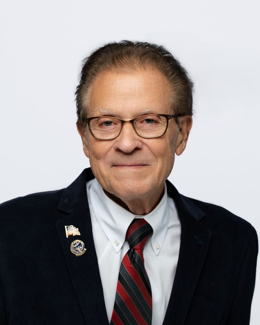 A person in a dark suit and glasses appears in a series of four similar headshot photos.
