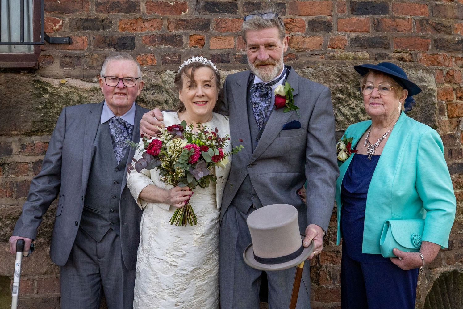 Bride and groom with parents during relaxed family wedding portraits at Windmill Farm, Burscough after their Southport Town Hall ceremony.