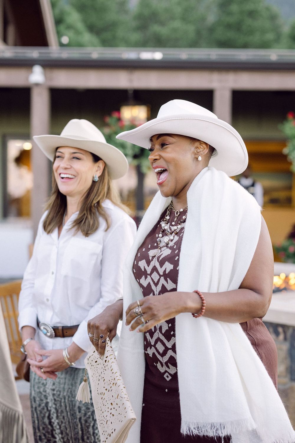 Couple laughing and sharing a light moment together while wearing casual outfits with a white scarf accessory.