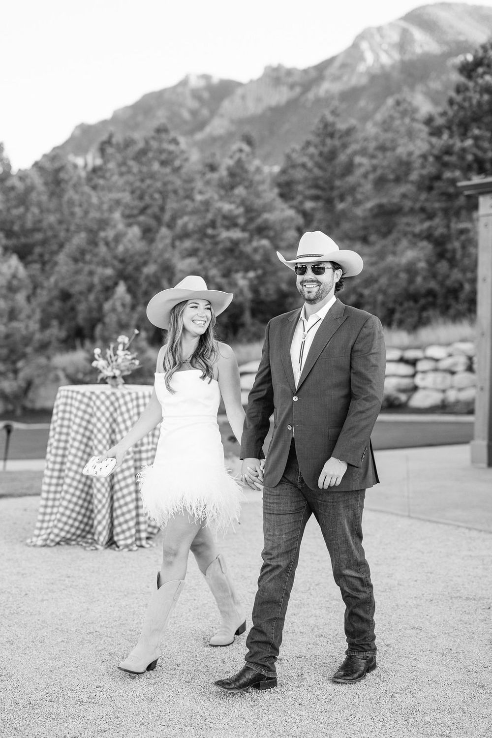 Black and white photo of a family walking together outdoors with mountains in the background.