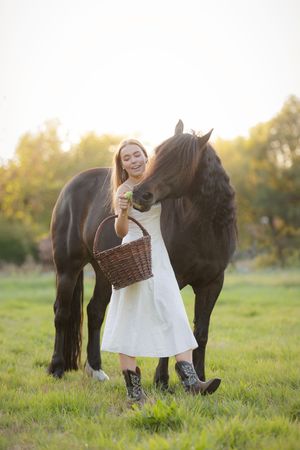 Paard eet appel uit hand van baasje