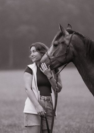 Paard en eigenaar tijdens een fotoshoot op een bewolkte dag