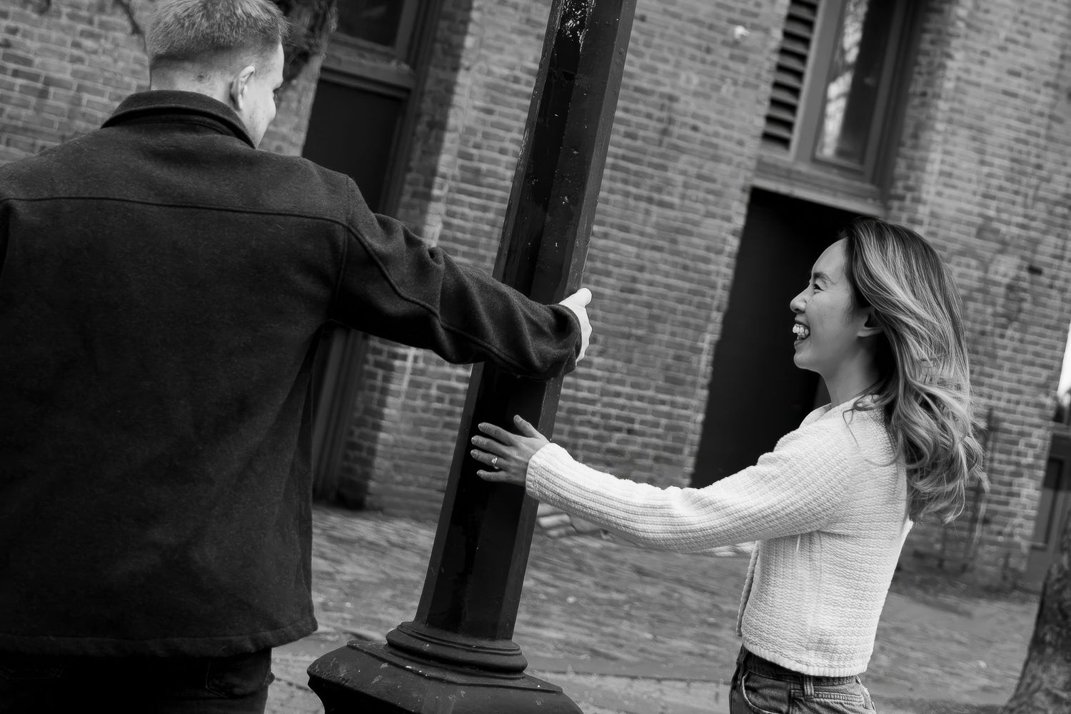 A series of black and white photos showing a couple dancing and embracing in front of a brick building.