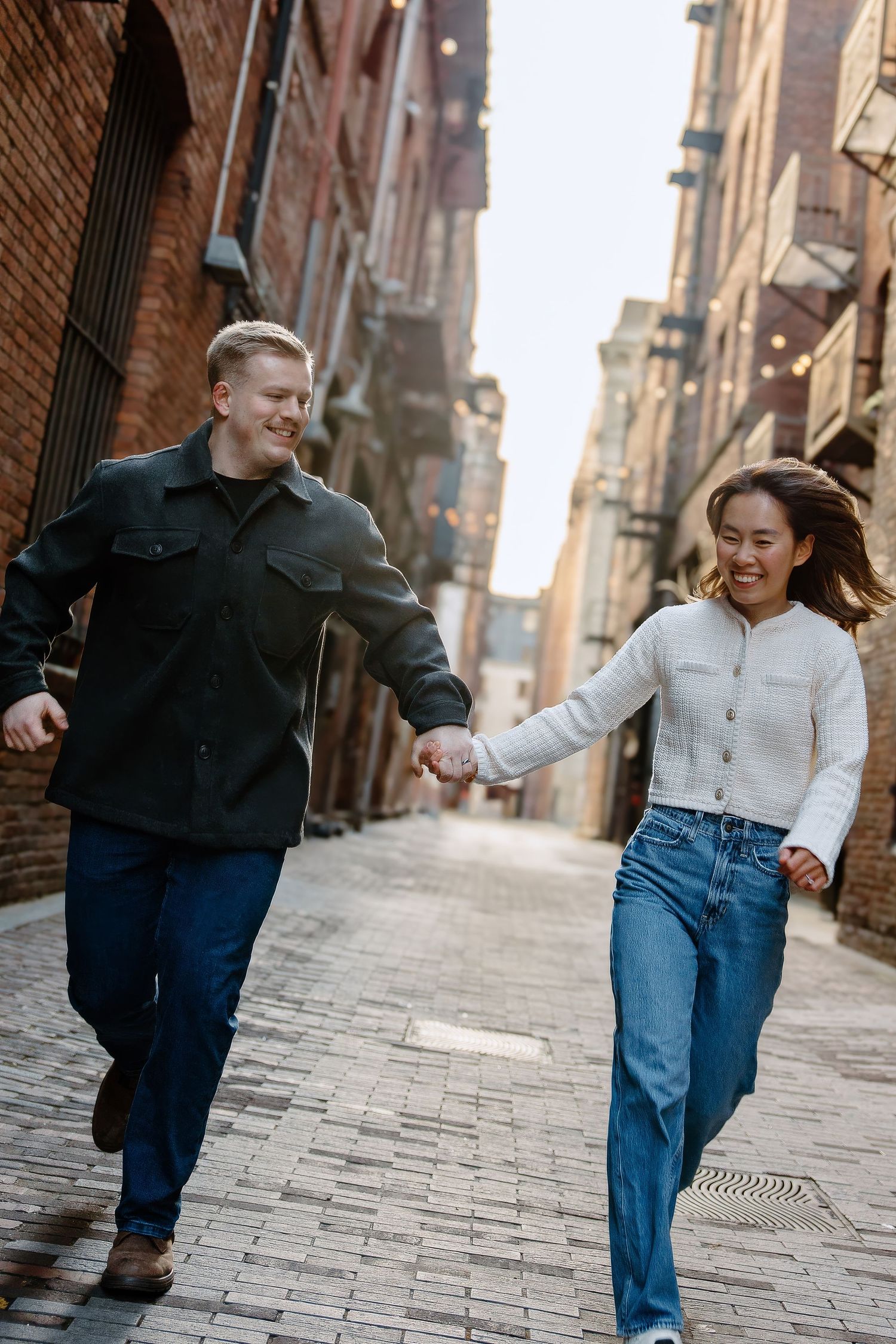 A series of candid shots showing two people walking and dancing together on a cobblestone street.