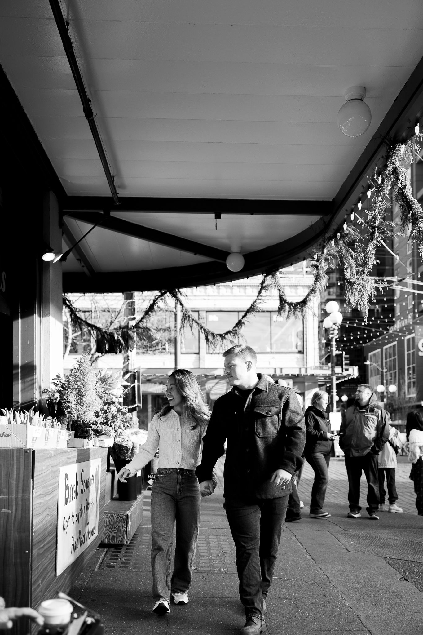 Black and white images of people walking under a decorated outdoor covered walkway.