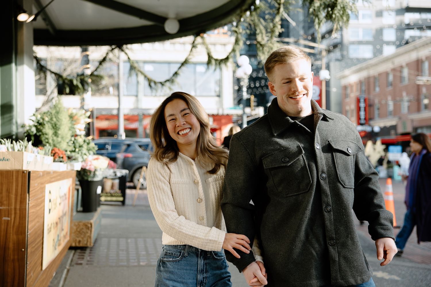 A couple shares a joyful moment together while walking through an urban area.