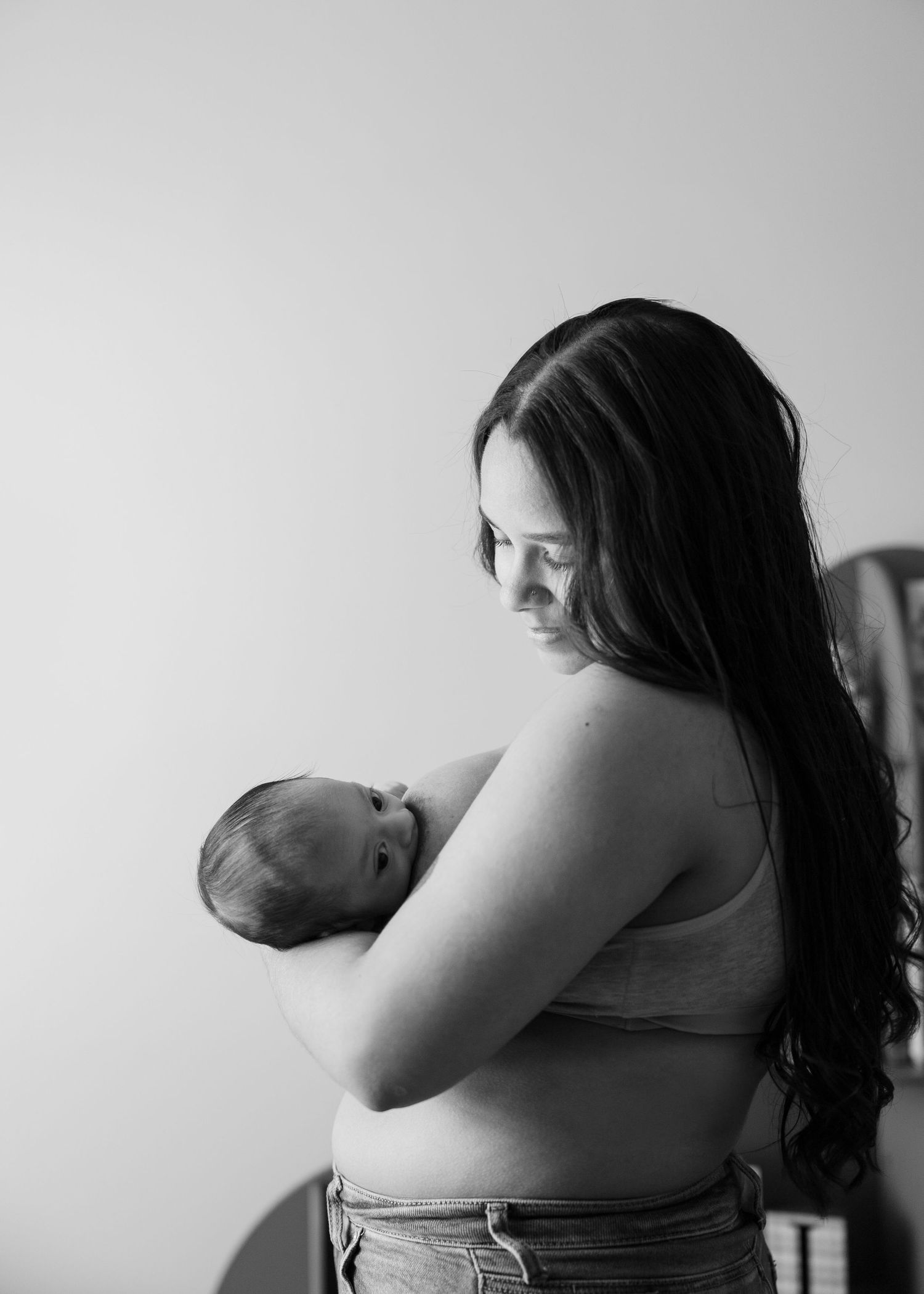 Lifestyle newborn session in Houston home featuring mom nursing her baby boy