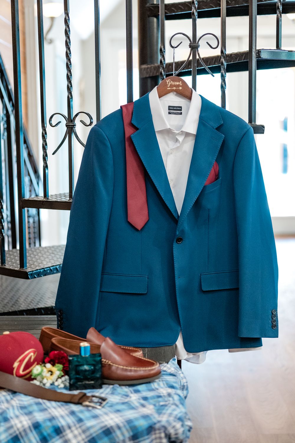 Blue suit jackets with red ties hanging on display for wedding preparation.