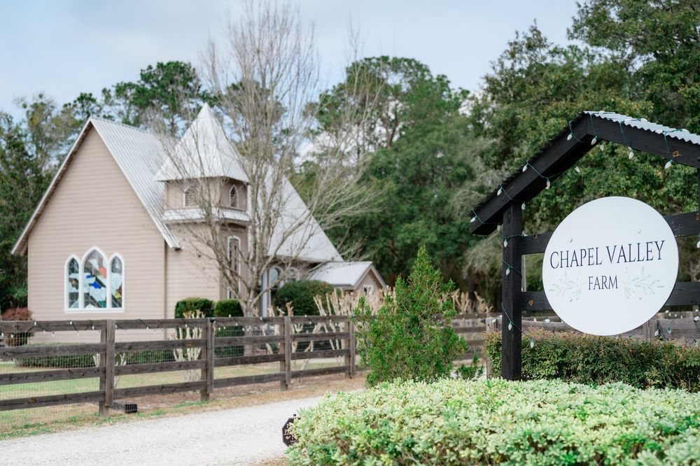 Exterior view of Chapel Valley Farm wedding venue with white buildings and trees.