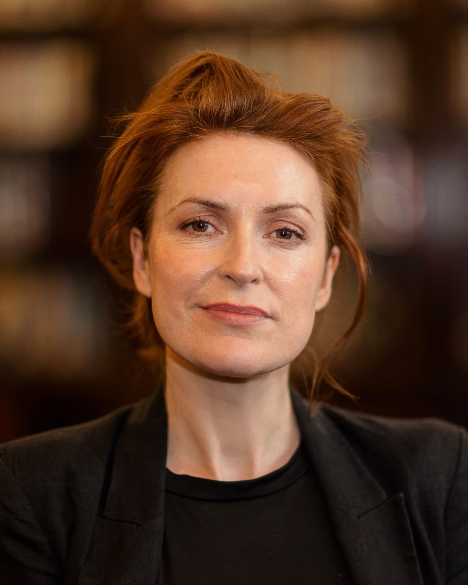 A sequence of six headshots showing different angles and expressions of a person with red hair wearing black.