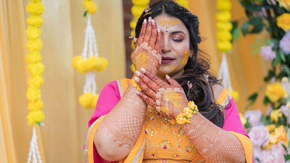 Traditional Indian wedding ceremony with marigold flower decorations and vibrant yellow and pink colors.