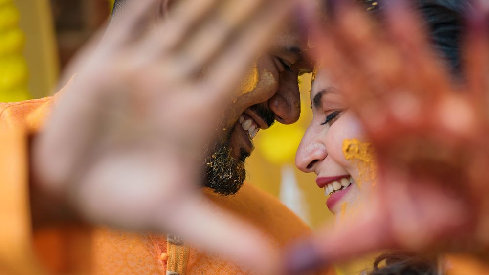 A collage of hands making heart shapes against a blurred warm-toned background with smiling people.