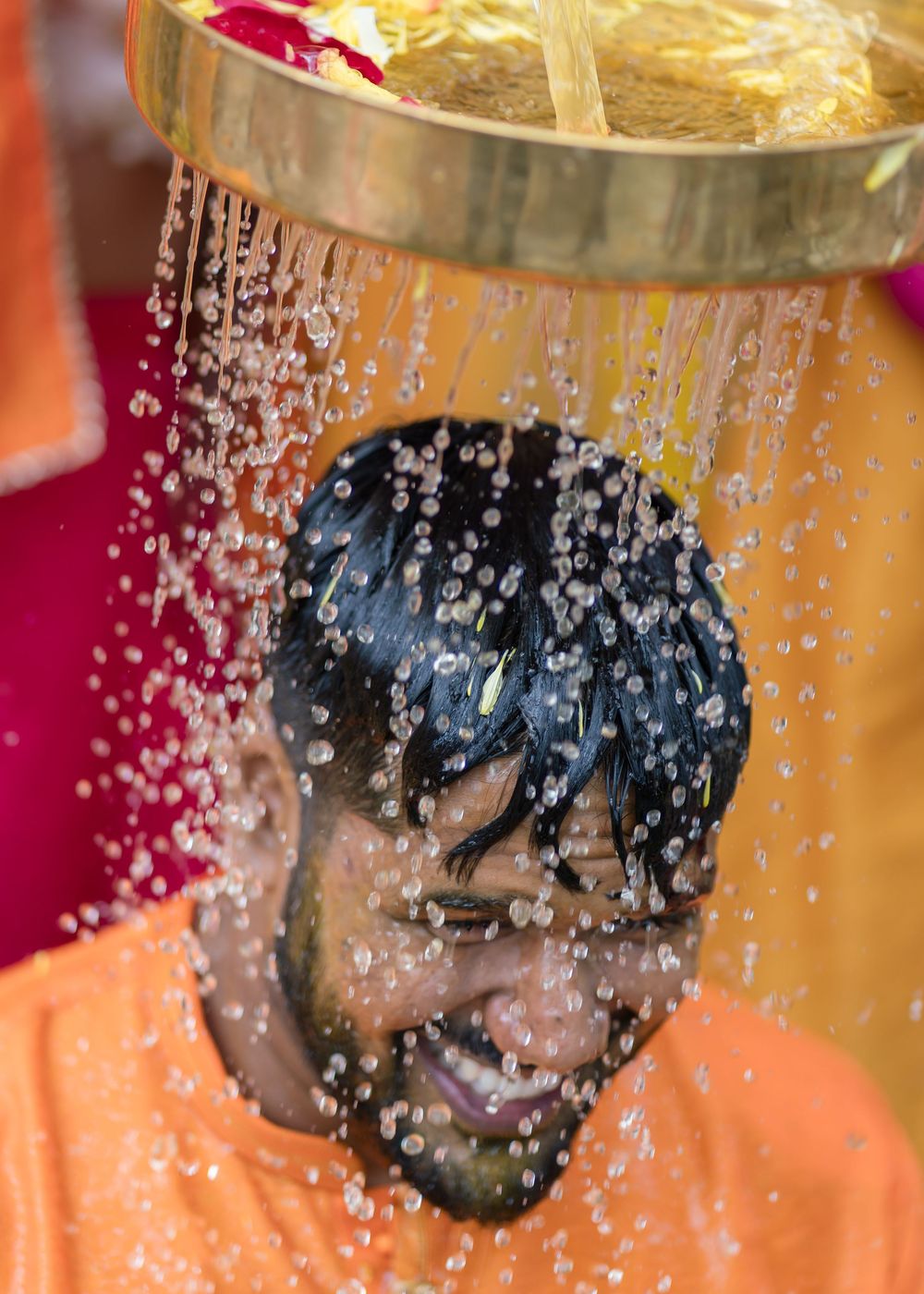 A sequence of images showing water droplets splashing and spraying in a dynamic pattern against an orange background.