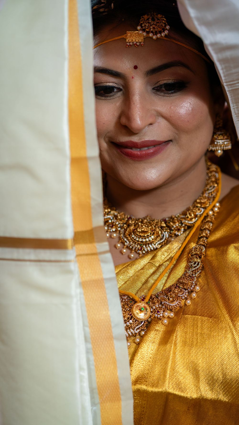 Close-up view of traditional Indian bridal jewelry featuring an ornate gold necklace and matching accessories.