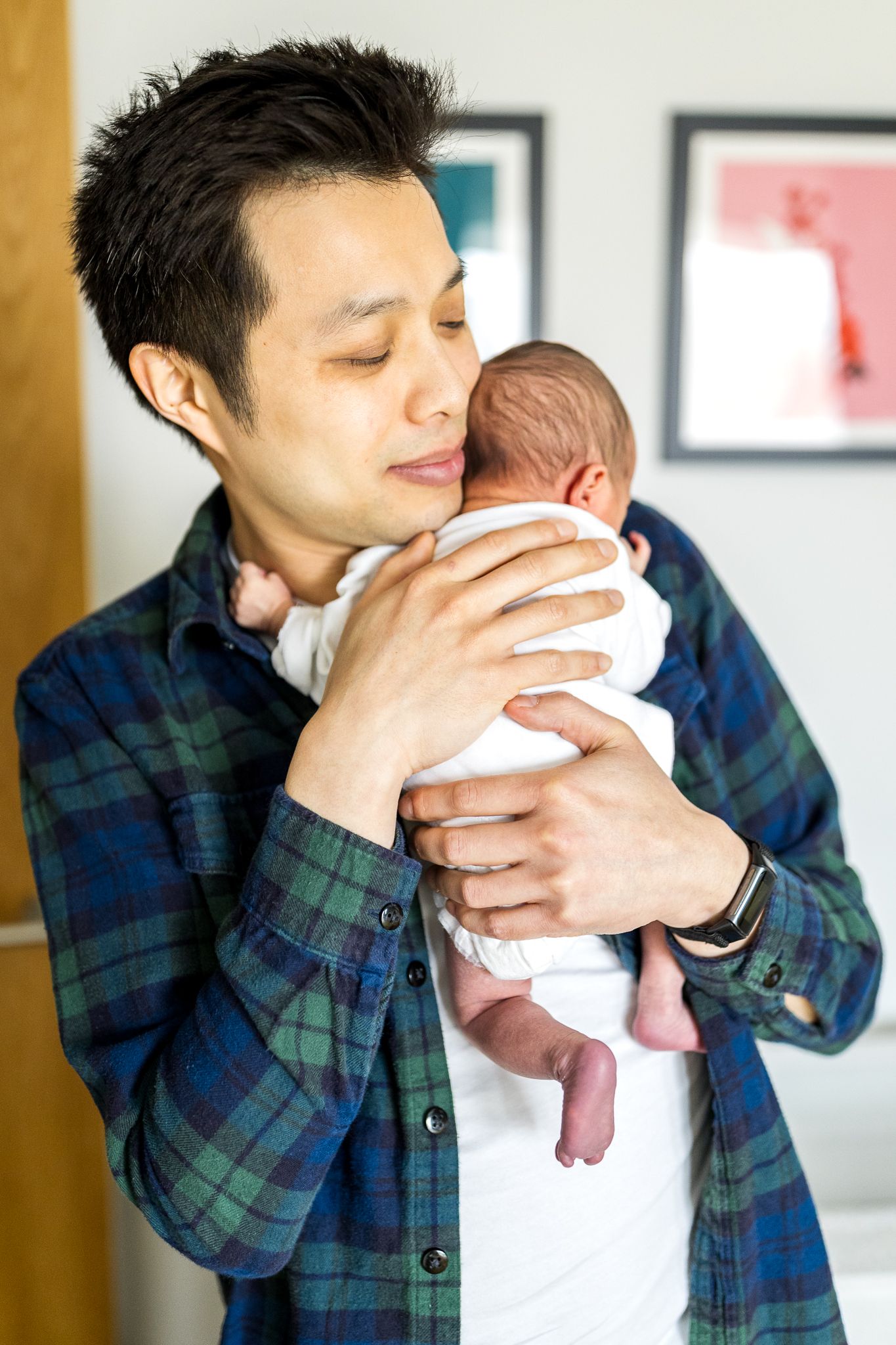dad holds his tiny newborn daughter close to his chest