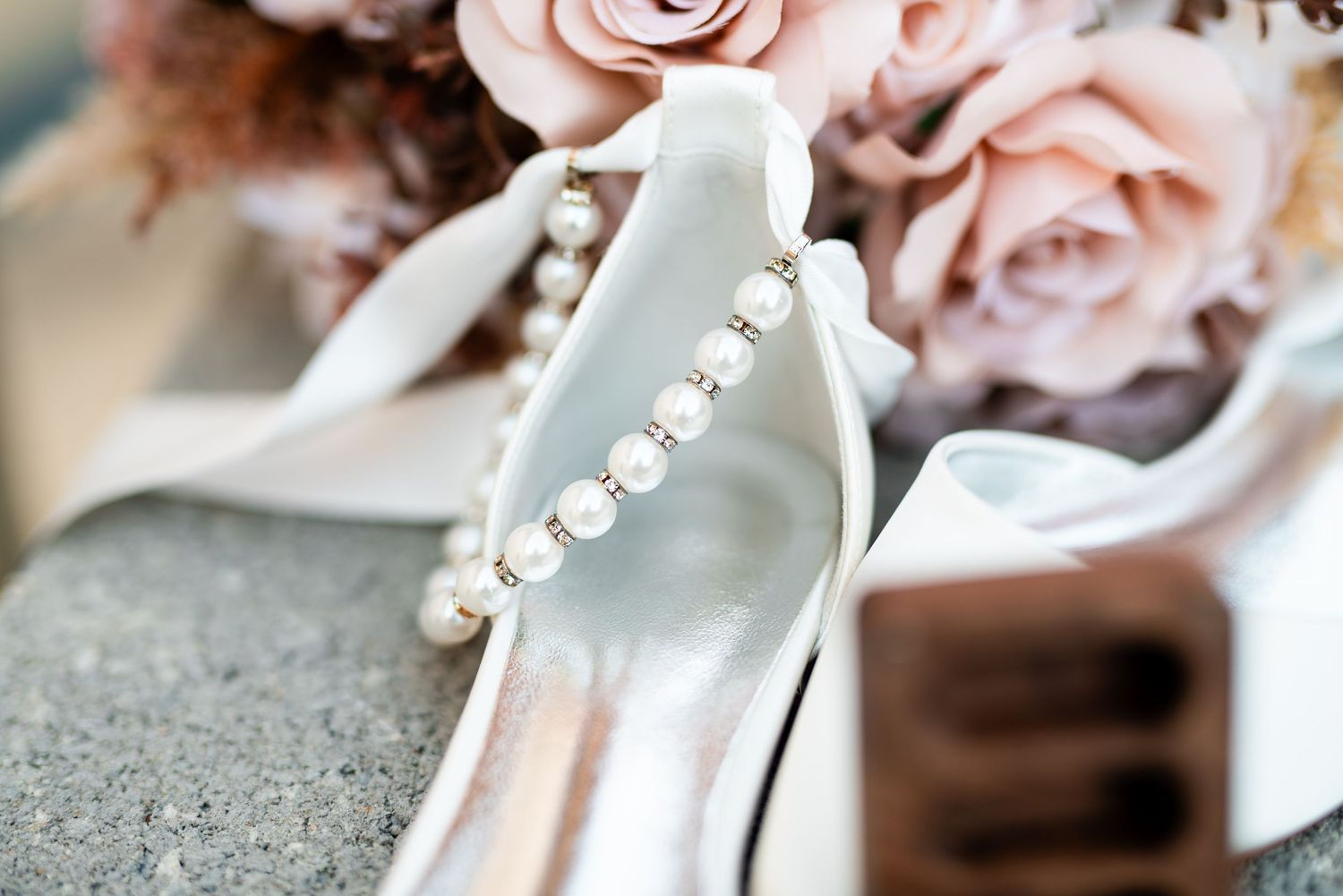 Delicate pink roses and white satin ribbons create an elegant wedding detail arrangement.