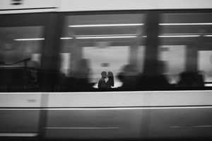 A series of black and white photographs showing blurred motion of subway trains passing through a station.