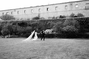 A series of black and white wedding photos showing a couple walking together in an outdoor garden setting.