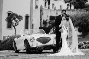 Black and white wedding photos with vintage car and stone building backdrop.
